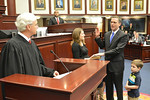 Rep. Eric Eisnaugle, R-Orlando, takes the oath of office in the House from Chief Justice Ricky Polston Wednesday as his wife Carrie holds the bible and his son Eric, 4, looks on. Photo by Bill Cotterell.