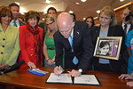 Backed by state legislators and child-protection advocates, Gov. Rick Scott signs legislation Tuesday to toughen state penalties against sexual predators. Photo by Bill Cotterell
