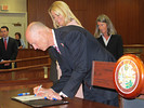 Gov. Rick Scott signs the mortgage-settlement legislation Tuesday while Attorney General Pam Bondi and Lynn Drysdale of Jacksonville, managing attorney for the consumer-law unit of Legal Aid, look on. Photo by Bill Cotterell.